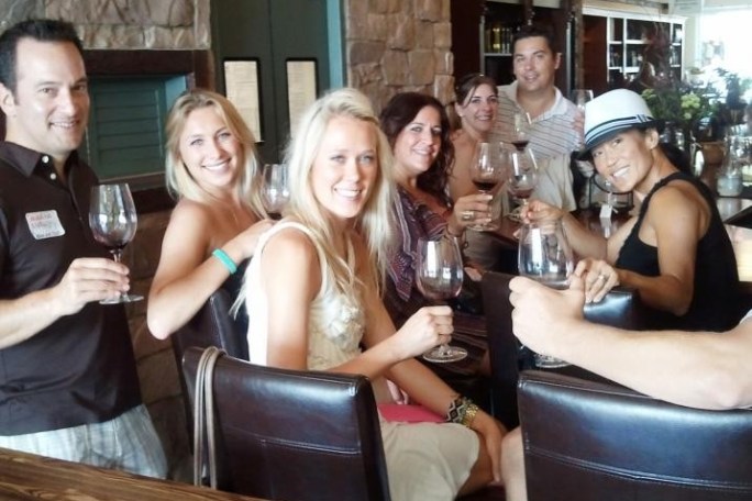 a group of people sitting at a table with wine glasses