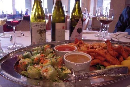 a plate of food and a bottle of wine on a table